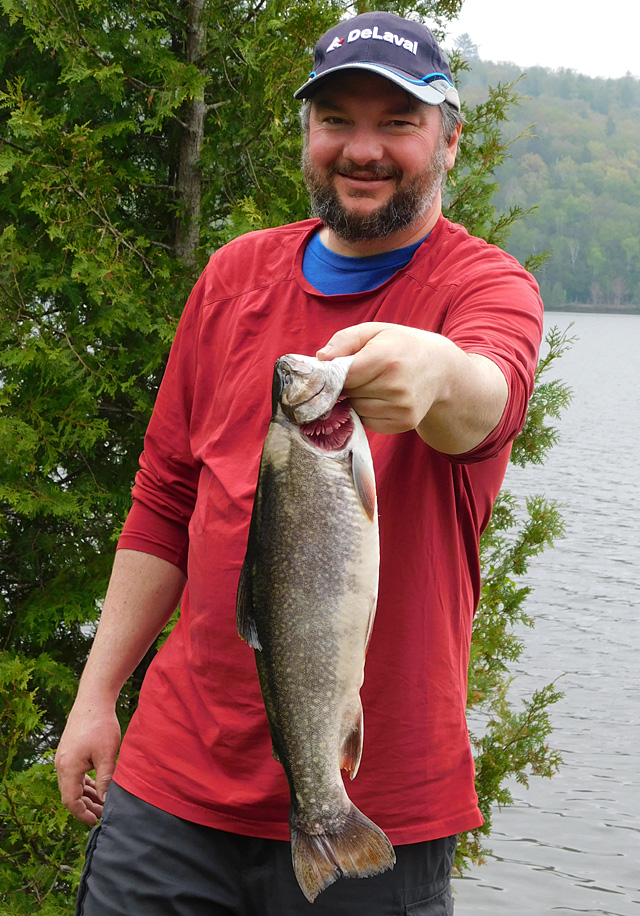 This is a photo of a man holding a 2 pound Brook Trout